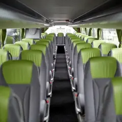 Widok panoramiczny wnętrza autokaru FlixBus z rzędami zielono-szarych siedzeń.