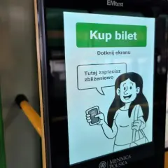 Ekran automatu MPK z napisem "Kup bilet". Grafika kobiety pokazuje, jak kupić bilet elektroniczny zbliżeniowo.