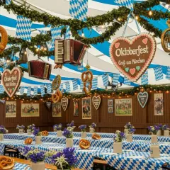 Wystrój namiotu z preclami, akordeonami i sercem z napisem "Oktoberfest" sugeruje, że to właśnie tutaj jest Oktoberfest.