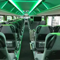 Wnętrze Flixbus autobusu z zielonym oświetleniem. Puste, wygodne siedzenia czekają na pasażerów.