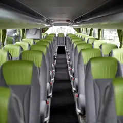 Wnętrze autokaru FlixBus z rzędami zielono-szarych siedzeń. Idealne miejsce na komfortową flixbus rezerwacja miejsc.