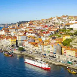 Porto, Lizbona: malownicze kolorowe kamienice nad rzeką Duero, statki wycieczkowe i tradycyjne łodzie.