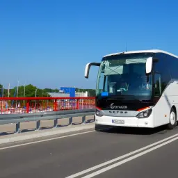Biały autokar Voyager na moście, w tle przystań jachtowa. Trasa Kraków - Krynica-Zdrój.