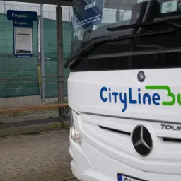 Autobus CityLineBus czeka na pasażerów na przystanku. Może to być podróż z Kielc na lotnisko w Katowicach.