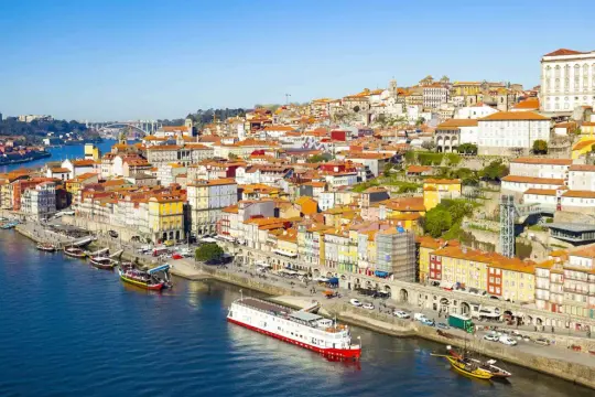 Porto, Lizbona: malownicze kolorowe kamienice nad rzeką Duero, statki wycieczkowe i tradycyjne łodzie.