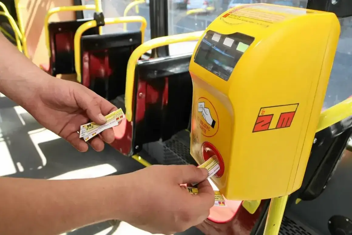 Ręka wsuwa bilet 20 minutowy Warszawa do żółtego kasownika w autobusie.