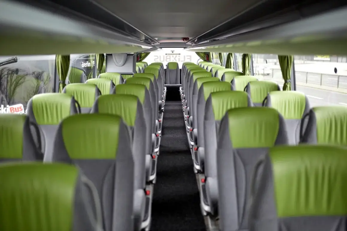 Wnętrze autokaru FlixBus z rzędami zielono-szarych siedzeń. Idealne miejsce na komfortową flixbus rezerwacja miejsc.
