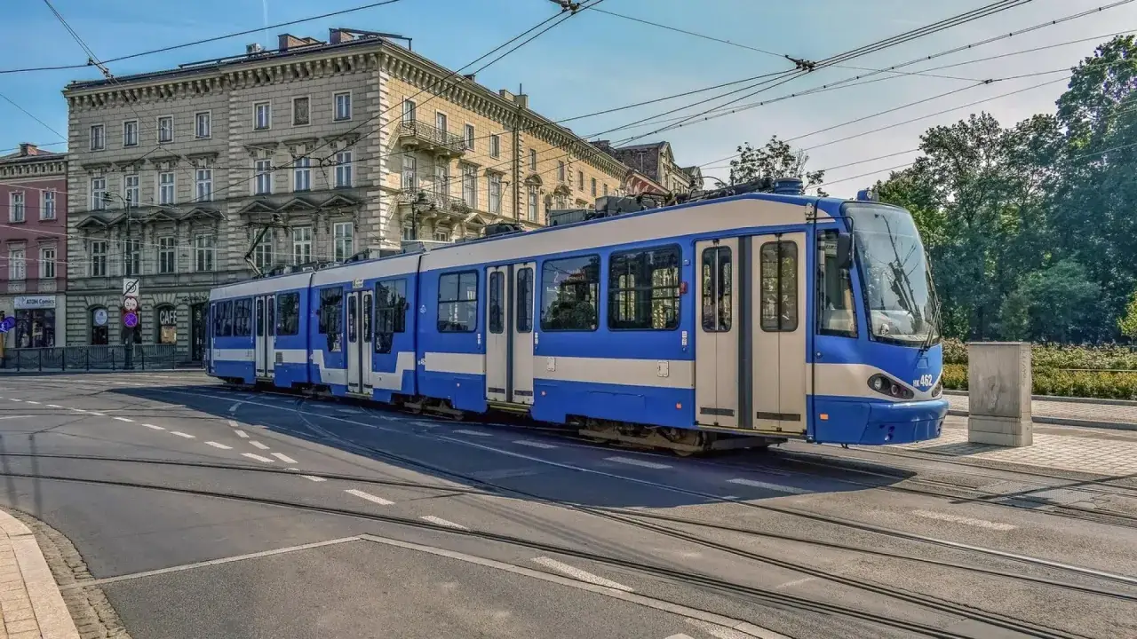 Kraków: Niebiesko-biały tramwaj na tle kamienicy. Idealny na weekendowy bilet rodzinny.