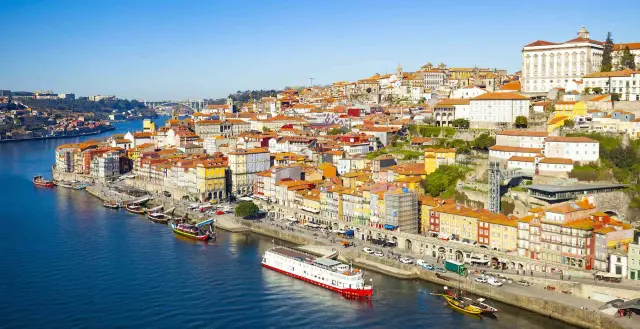 Porto, Lizbona: malownicze kolorowe kamienice nad rzeką Duero, statki wycieczkowe i tradycyjne łodzie.